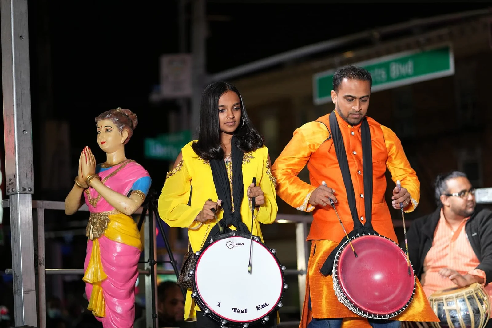 Updated home 4 Tassa musicians in yellow and orange outfits perform on drums during the evening celebration.
