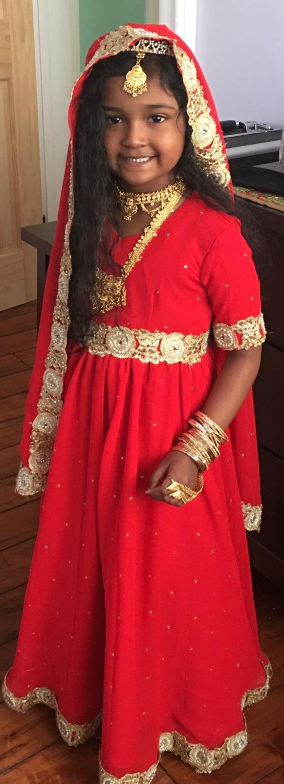 Mother Lakshmi 2 Lilly in red and gold cultural dress as a child.