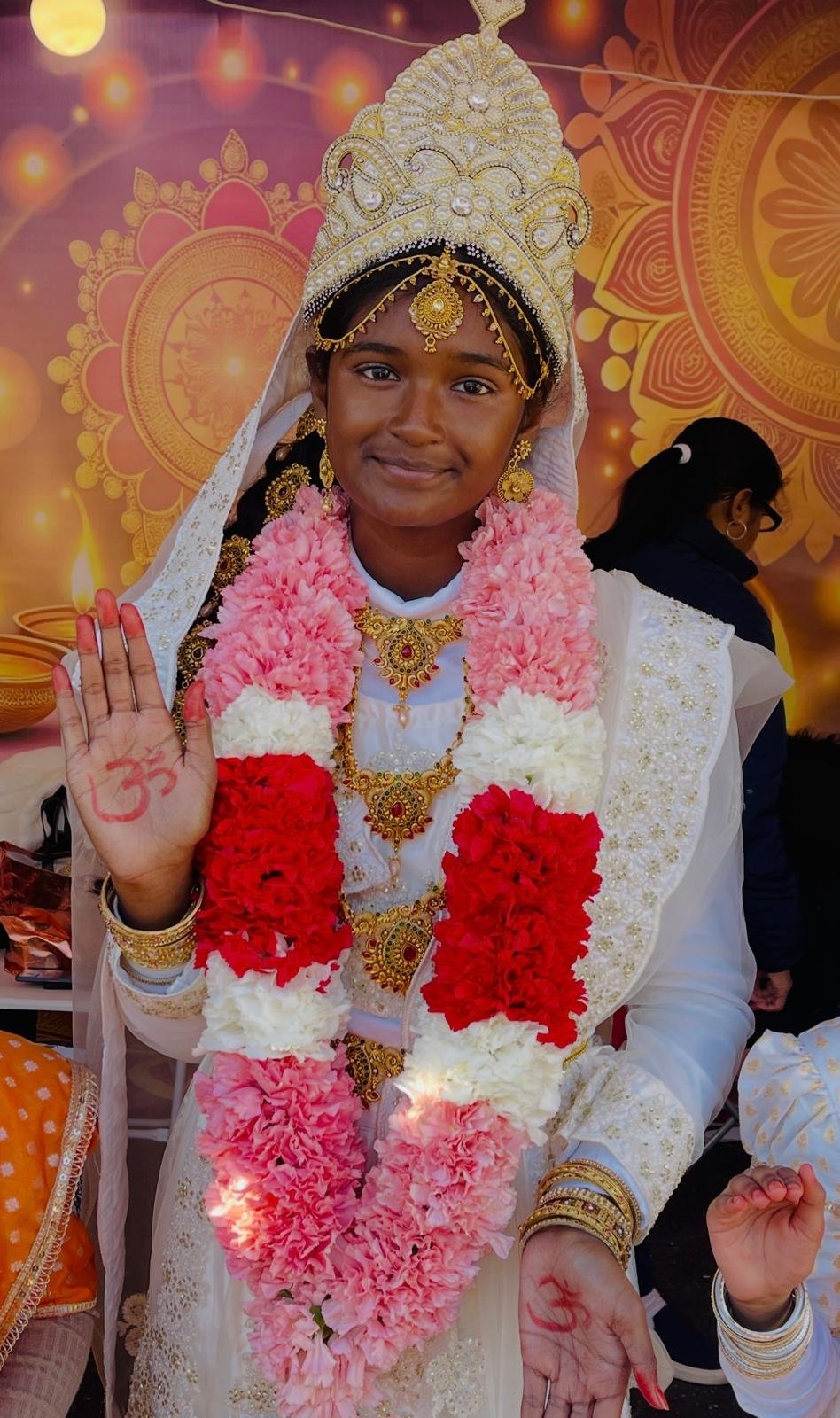 Mother Lakshmi 5 Lilly portraying Mother Lakshmi in white ceremonial dress.